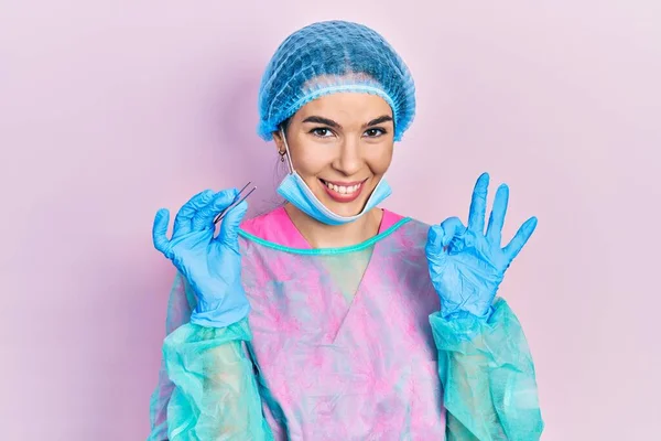 Giovane Donna Bruna Indossando Uniforme Chirurgo Tenendo Pinzette Facendo Segno — Foto Stock