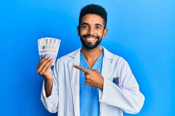 Hombre Hispano Guapo Con Barba Vistiendo Uniforme Médico Sosteniendo Pesos — Foto de Stock