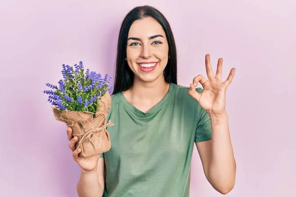 Όμορφη Γυναίκα Μπλε Μάτια Κρατώντας Λεβάντα Φυτό Κάνει Υπογράψει Δάχτυλα — Φωτογραφία Αρχείου