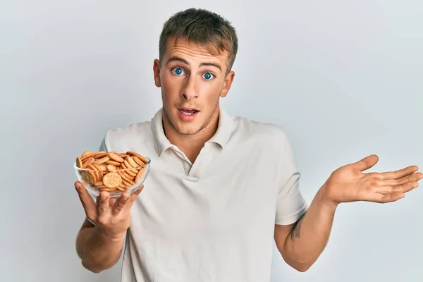 Jeune Homme Caucasien Tenant Bol Biscuits Salés Célébrant Réalisation Avec — Photo
