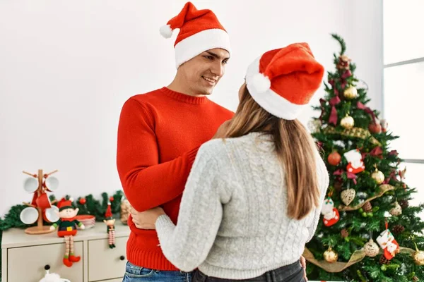 Pareja Joven Abrazando Sonriendo Feliz Vistiendo Sombrero Navidad Casa —  Fotos de Stock