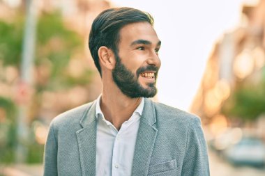 Genç İspanyol işadamı gülümseyerek şehirde mutlu mesut duruyor..