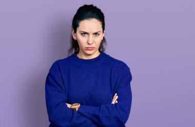 Gündelik kıyafetler giyen genç İspanyol kadın şüpheci ve gergin. Yüzünde çapraz kollu tasvip etmeyen ifade. negatif kişi. 