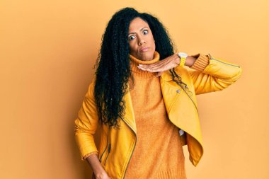 Orta yaşlı Afro-Amerikalı kadın yün kazak ve deri ceket giyip boğazını bıçak niyetine kesiyor, saldırganlığı şiddetli bir şiddetle tehdit ediyor. 