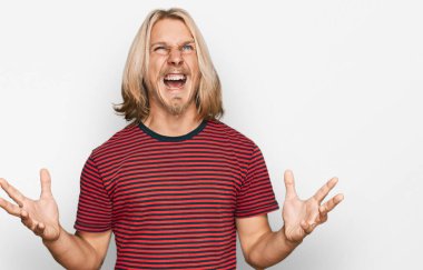 Sarışın, uzun saçlı, sıradan çizgili tişört giyen, deli gibi bağıran, agresif ifade ve kollarıyla bağıran beyaz bir adam. hüsran kavramı. 