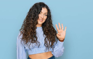 Latin kökenli genç bir kız günlük kıyafetler giyer ve parmaklarıyla dört numarayı gösterir.. 