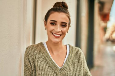 Güzel esmer kadın güler yüzlü mutlu ve kendinden emin sonbaharın güneşli bir gününde şehirde.