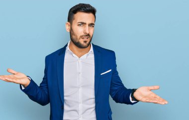 İş ceketi giyen genç İspanyol adam hiçbir şeyden habersiz ve kolları açık, hiçbir fikri yok.. 