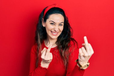 Young hispanic woman wearing casual clothes showing middle finger doing fuck you bad expression, provocation and rude attitude. screaming excited 
