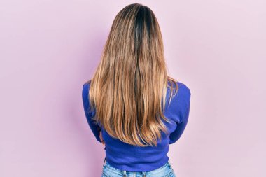 Güzel İspanyol kadın, sıradan mavi gömlekli, arkası dönük, çapraz kollarla başka tarafa bakıyor. 