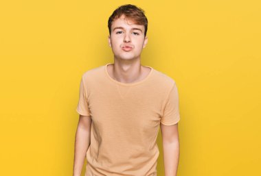 Kafkasyalı genç bir adam, günlük kıyafetler giyip kameraya bakıyor ve canlı yayında öpüşüyor. Sevimli ve seksi. aşk ifadesi. 