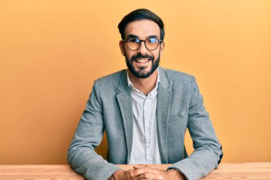 Ofiste mutlu ve havalı bir gülümsemeyle çalışan genç bir İspanyol. şanslı kişi. 