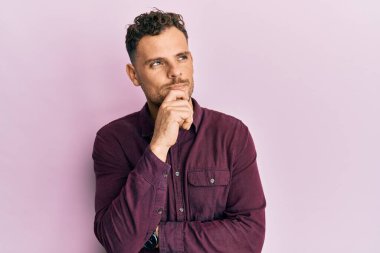 Gündelik kıyafetler giyen genç İspanyol adam şüphe üzerine yoğunlaşmıştı. Parmakları çenesinde ve yukarı bakıyordu. 