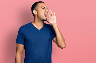 Sıradan tişörtler giyen genç Afro-Amerikalı adam el ele tutuşup bağırıyor ve bağırıyordu. iletişim konsepti. 