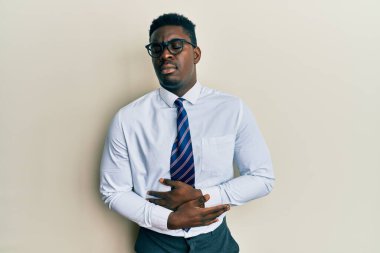 Yakışıklı, gözlüklü, iş gömleği giyen ve eli karnında kravat takan siyahi bir adam. Çünkü mide bulantısı, acı verici bir hastalık kendini iyi hissetmiyor. Ağrı kavramı. 