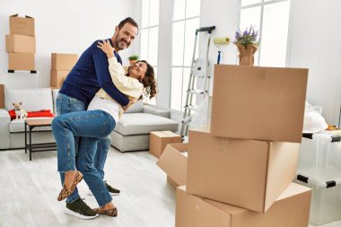 Orta yaşlı İspanyol çift mutlu bir şekilde gülümsüyor ve yeni evinde dans ediyor..