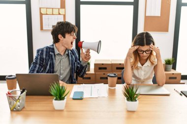 İş adamı ofiste megafonla ortağına bağırıyor..