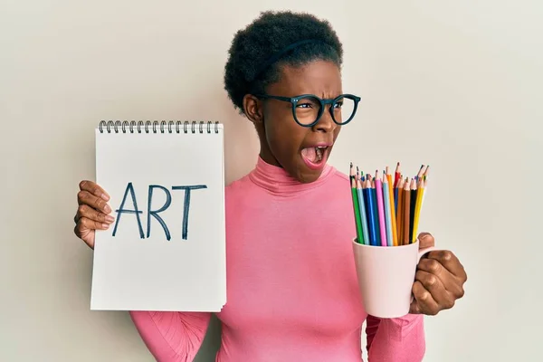 Chica Afroamericana Joven Sosteniendo Cuaderno Arte Lápices Colores Enojado Loco —  Fotos de Stock