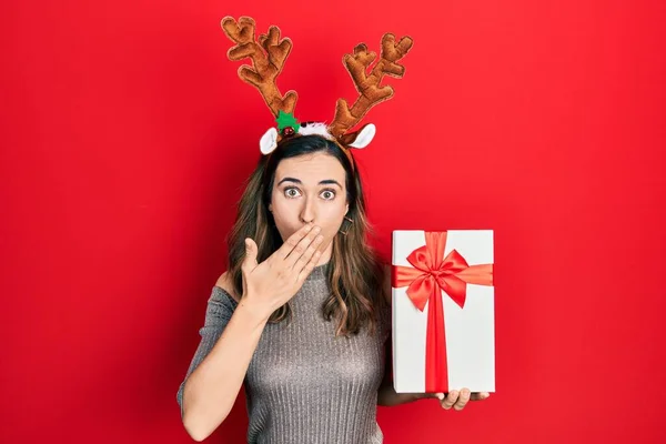 Joven Chica Hispana Con Sombrero Navidad Ciervos Sosteniendo Regalo Cubriendo —  Fotos de Stock