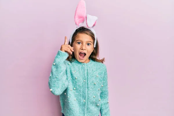 Gyönyörű Kislány Aranyos Húsvéti Nyuszifüleket Visel Ujjal Mutogatva Sikeres Ötletre — Stock Fotó