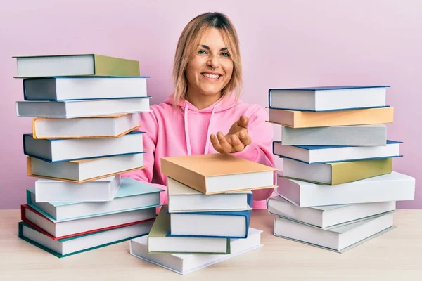 Joven Mujer Caucásica Sentada Mesa Con Libros Sonriendo Alegre Ofreciendo —  Fotos de Stock