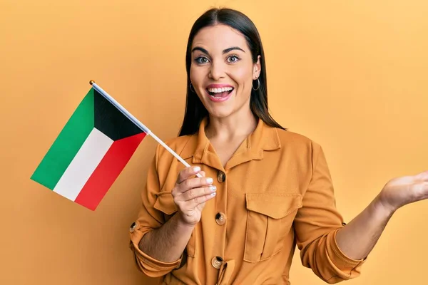 Νεαρή Μελαχρινή Γυναίκα Κρατώντας Kuwait Σημαία Γιορτάζει Επίτευγμα Χαρούμενο Χαμόγελο — Φωτογραφία Αρχείου