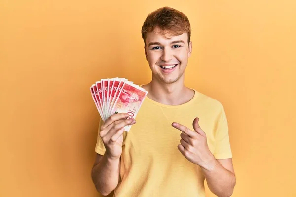 Giovane Uomo Caucasico Possesso Shekel Israeliani Banconote Sorridenti Felice Indicando — Foto Stock