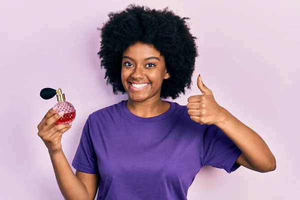 Joven Mujer Afroamericana Sosteniendo Perfume Sonriendo Feliz Positivo Pulgar Hacia — Foto de Stock