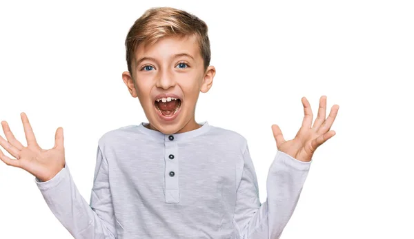 クレイジーを祝うカジュアルな服を着ている小さな白人の少年は 腕を上げ 興奮して叫んで目を開けて成功したことに驚いています 勝者のコンセプト — ストック写真