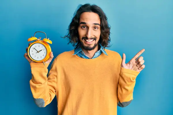 Giovane Uomo Ispanico Tenendo Sveglia Sorridente Felice Indicando Con Mano — Foto Stock