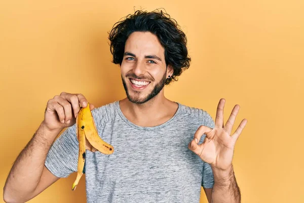 Snygg Latinamerikansk Man Som Håller Bananskal Gör Tecken Med Fingrar — Stockfoto