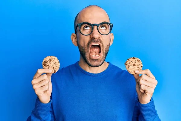 Junger Hispanischer Mann Mit Schokoladenkeksen Wütend Und Verrückt Schreiend Frustriert — Stockfoto