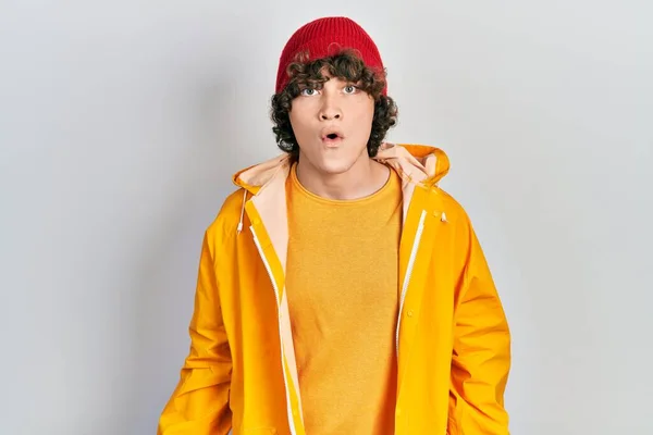 Handsome Young Man Wearing Yellow Raincoat Scared Amazed Open Mouth — Stock Photo, Image