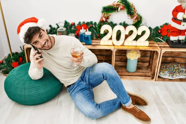 Молодий Іспаномовний Чоловік Посміхається Щасливим Носінням Різдвяного Капелюха Розмовляючи Смартфону — стокове фото