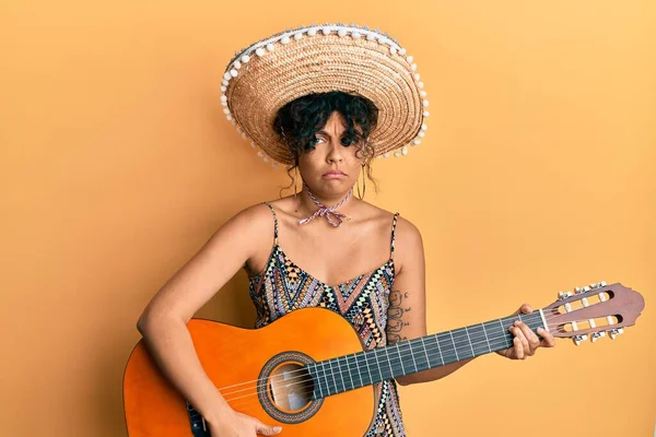 メキシコの帽子をかぶっている若いヒスパニック系の女性は クラシックギターを弾いて落ち込んでおり 苦痛のために心配し 怒って恐れています 悲しい表情 — ストック写真