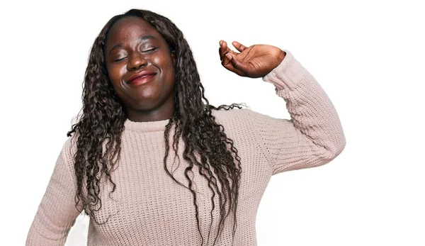 Genç Afrikalı kadın yün bir kazak giyiyor, geriniyor, yorgun ve rahat, uykulu ve sabahın erken saatlerinde esniyor. 