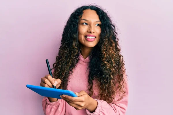 若いラテン語の女性を使用してタッチパッドの書き込み画面に笑みを浮かべて横に見て離れて考えて見つめて — ストック写真