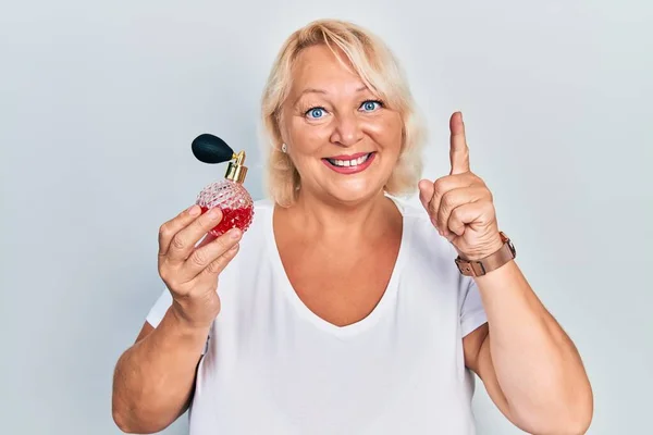 Middle Age Blonde Woman Holding Perfume Smiling Idea Question Pointing — Stock Photo, Image