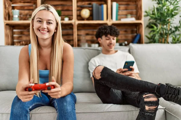 부부가 행복하게 웃으면서 비디오 게임을 집에서 스마트폰을 사용하는 — 스톡 사진