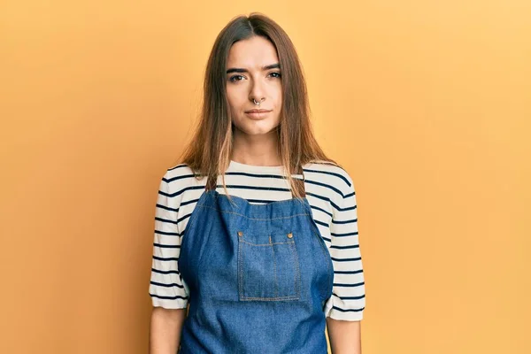 Young Hispanic Woman Wearing Barber Apron Serious Expression Face Simple — 스톡 사진