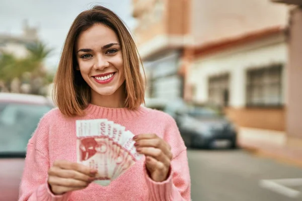 年轻的高加索女孩高兴地微笑着 在城里拿着冰原克朗钞票 — 图库照片
