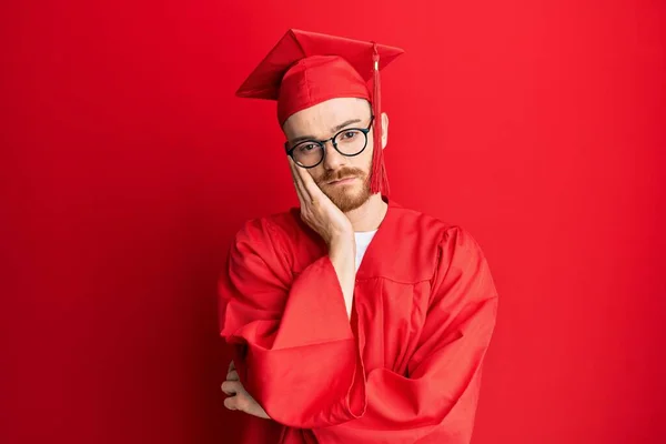 Jovem Ruivo Vestindo Chapéu Formatura Vermelho Roupão Cerimônia Pensando Parecendo — Fotografia de Stock