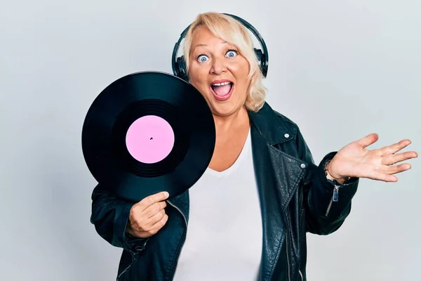 Middle Age Blonde Woman Holding Vinyl Disc Using Headphones Celebrating — Stock Photo, Image