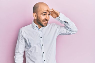 Gündelik kıyafetler giyen genç İspanyol adam çok mutlu ve gülümsüyor. Elleri başının üzerinde uzaklara bakıyor. arama kavramı. 