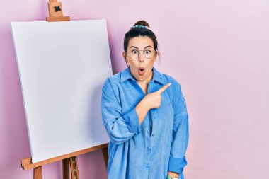 Ressam sehpasının yanında dikilen genç İspanyol kadın parmağını yana doğru göstererek şaşırdı ve ağzı açık hayret içinde kaldı.. 