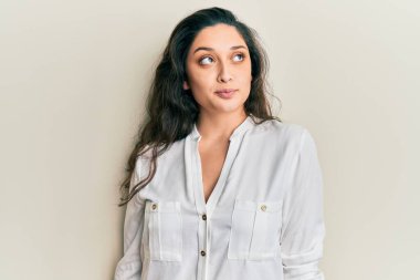 Güzel bir orta doğulu kadın günlük kıyafetler giyiyor gülümsüyor, yan tarafa bakıyor ve düşünüyor.. 