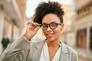 Genç Afrikalı Amerikalı iş kadını şehirde mutlu bir şekilde dikiliyor..