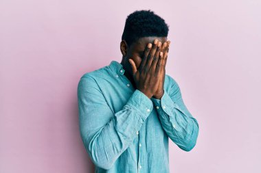 Yakışıklı, sıradan kıyafetler giyen, suratını ellerle örten ve ağlayan bir zenci. depresyon kavramı. 