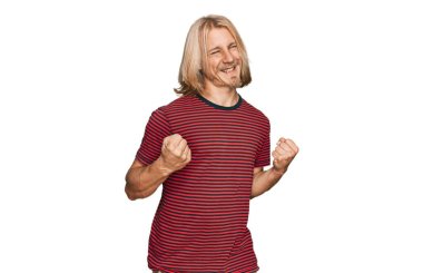 Sarışın, uzun saçlı, sıradan çizgili tişört giyen, kolları havada ve gözleri kapalı zaferi kutlayan beyaz bir adam. Kazanan konsept. 