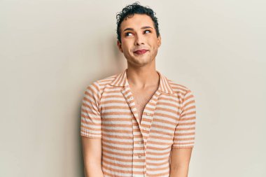 Makyaj yapan yakışıklı bir adam. Günlük tişört giyiyor. Gülümsüyor, yan tarafa bakıyor ve düşünüyor.. 